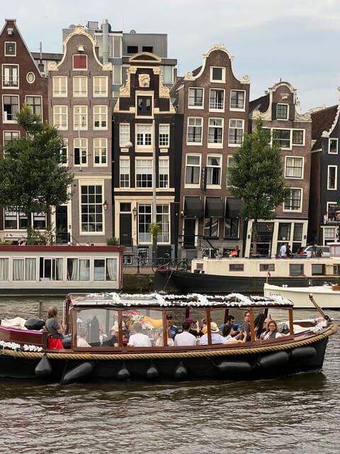 Amsterdam: Boat Tour with Optional Unlimited Drinks - Grand Hotel Amrâth, Montelbaanstoren, and the De Sluyswacht pass